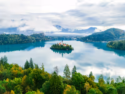 Aerial view of Lake Bled with island church and forested hills in Slovenia