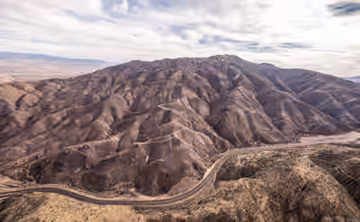 Aerial view of wildfire-scarred slopes on Mount Ord with road below in Arizona