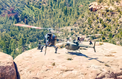 Airbus H125 and Bell 505 helicopters landed with rotors turning on remote Utah mesa