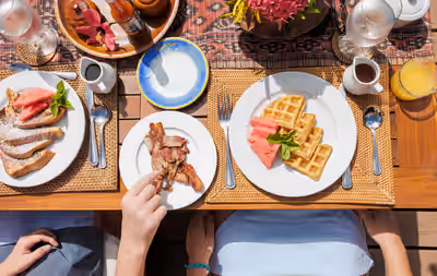 Waffles French toast and bacon served on outdoor breakfast table in Belize