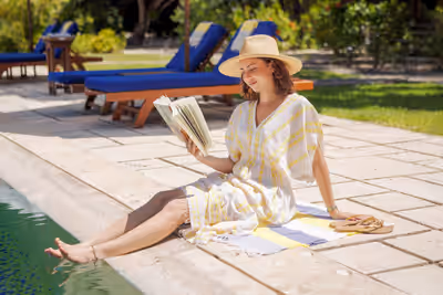 Woman reading a book by the pool at luxury resort in Belize