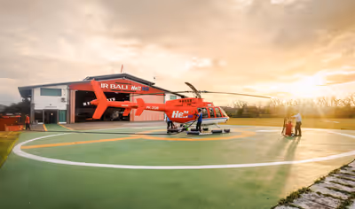Flight crew refueling and preparing Bell 407 helicopter for morning flight in Bali