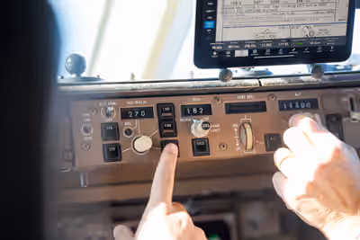 Pilots adjusting heading and altitude on Boeing 757 control panel during flight over Georgia