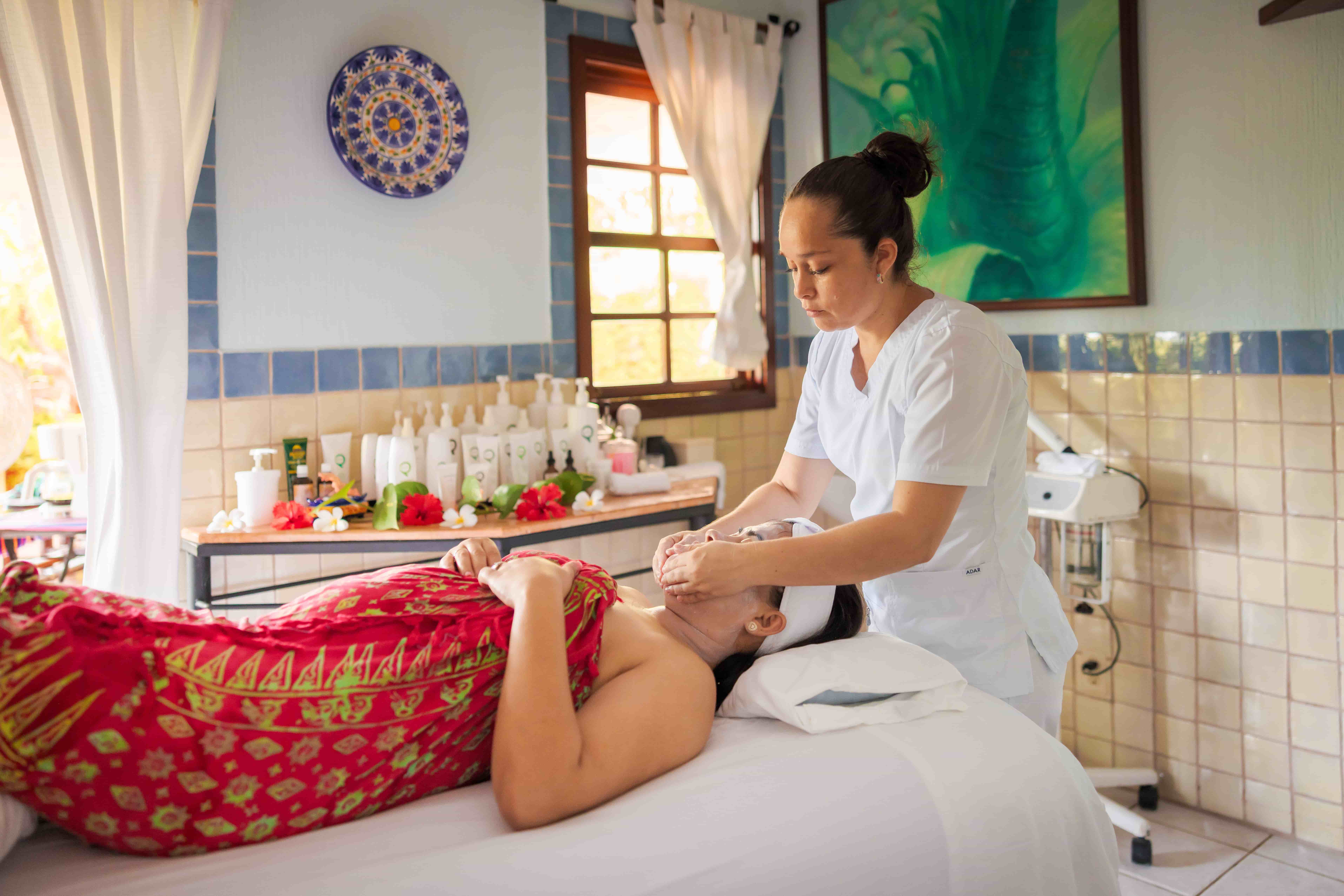 Woman receives facial massage at Chaa Creek spa, Belize Woman receiving facial massage from therapist in Chaa Creek spa