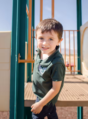 Smiling elementary school boy on a playground structure