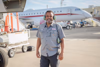 Smiling aircraft ground support technician with radio headset at Phoenix Sky Harbor Airport
