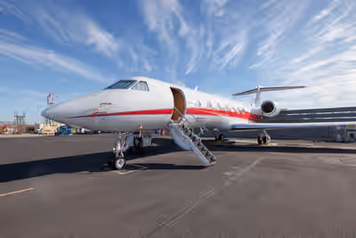 Gulfstream G550 business jet with open cabin door and stairway on the ramp at Phoenix Sky Harbor International Airport under a blue sky