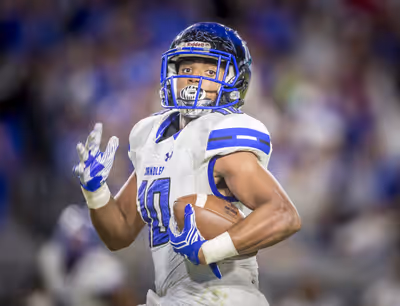 High school football player running the ball during championship game in Arizona
