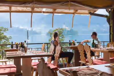 Two people seated at lakeside restaurant overlooking Lake Bled in Slovenia