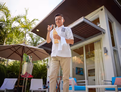 Butler serving wine at private resort villa at Chaa Creek resort in Belize