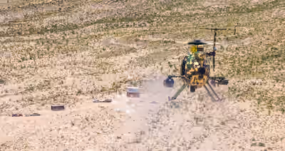 MD 530G helicopter firing weapons during live-fire attack dive in West Texas desert