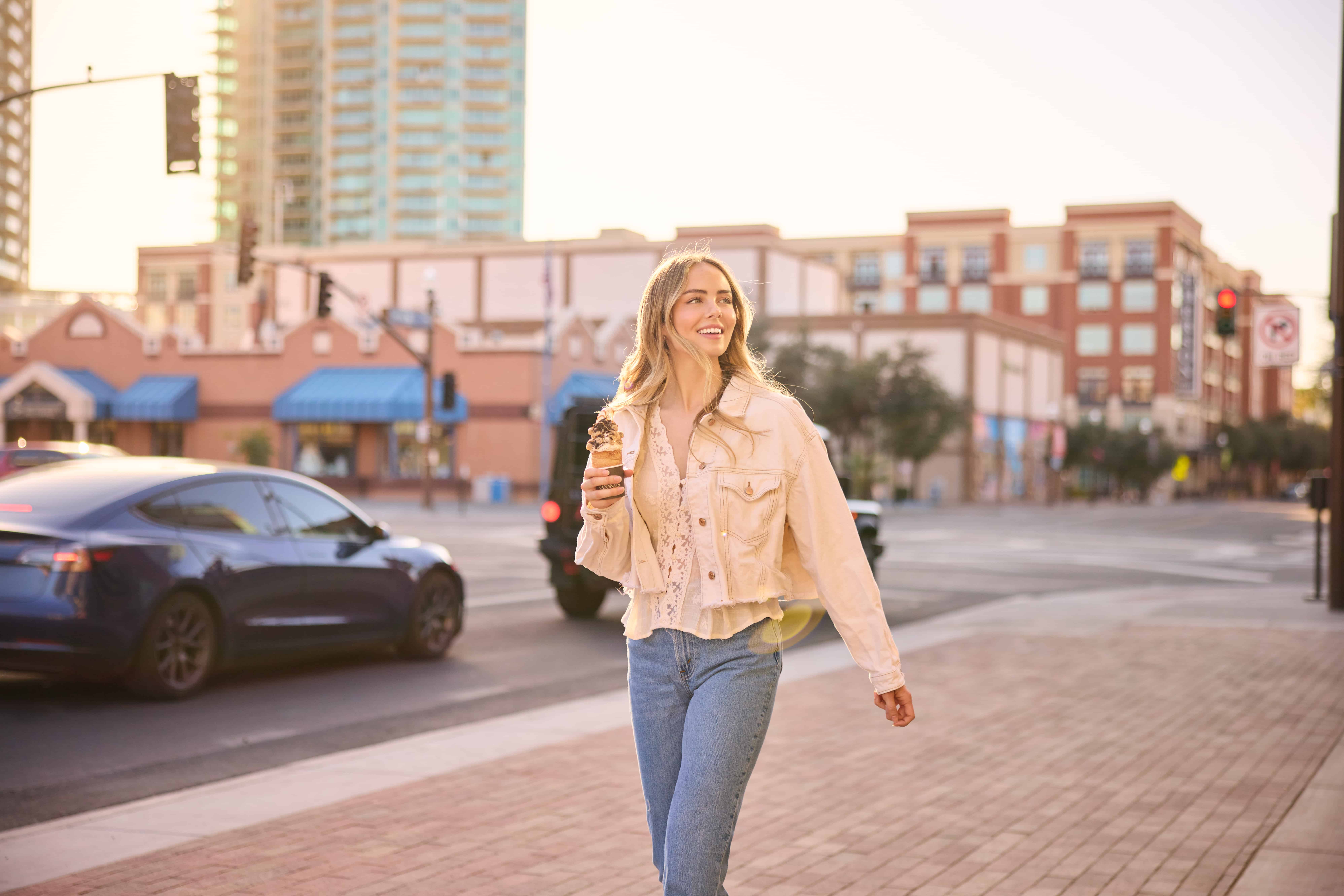 Young woman walking on Mill Avenue in downtown Tempe with an ice cream cone