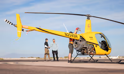 Robinson R22 being refueled on ramp with CFI and student at helicopter flight school in Chandler, Arizona