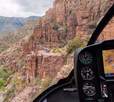 Robinson R44 helicopter landed on canyon mesa north of Phoenix, viewed air-to-air from cockpit