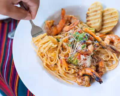 Seafood pasta with grilled shrimp and garlic bread at tropical resort in Belize