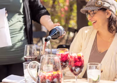 Server pouring red wine for customer at upscale outdoor restaurant in Tempe, Arizona
