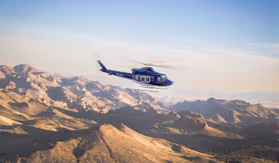Subaru Bell 412EPX helicopter flying over Arizona desert in morning light