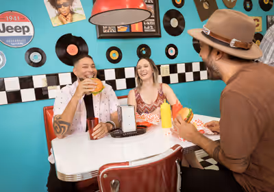 Three friends laughing and enjoying a retro diner scene in Tempe, Arizona