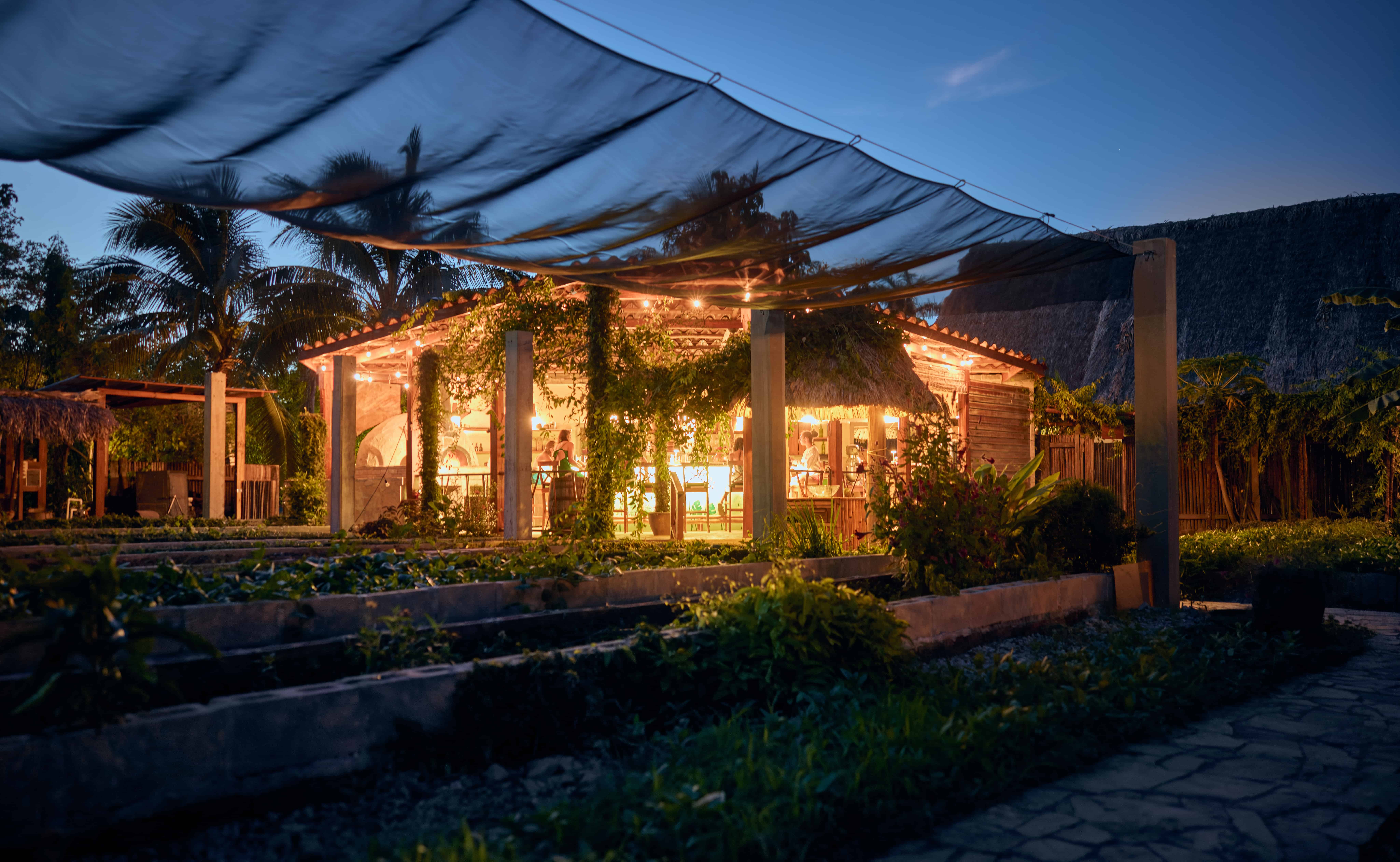 Turtle Inn pizzeria glowing at night in Placencia, Belize Turtle Inn's warmly lit pizzeria beneath a canopy at night in Belize