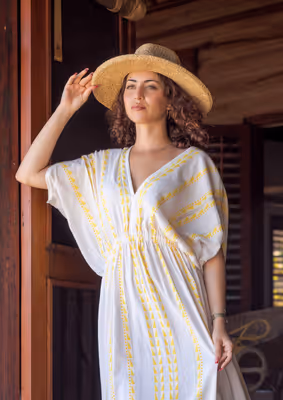 Woman looking out from villa doorway toward ocean at luxury resort in Belize